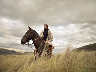 content woman sitting on horse in highland