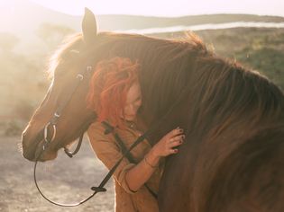 Woman Embracing Horse On Field
