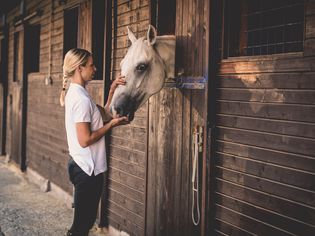 Woman with horse at stable